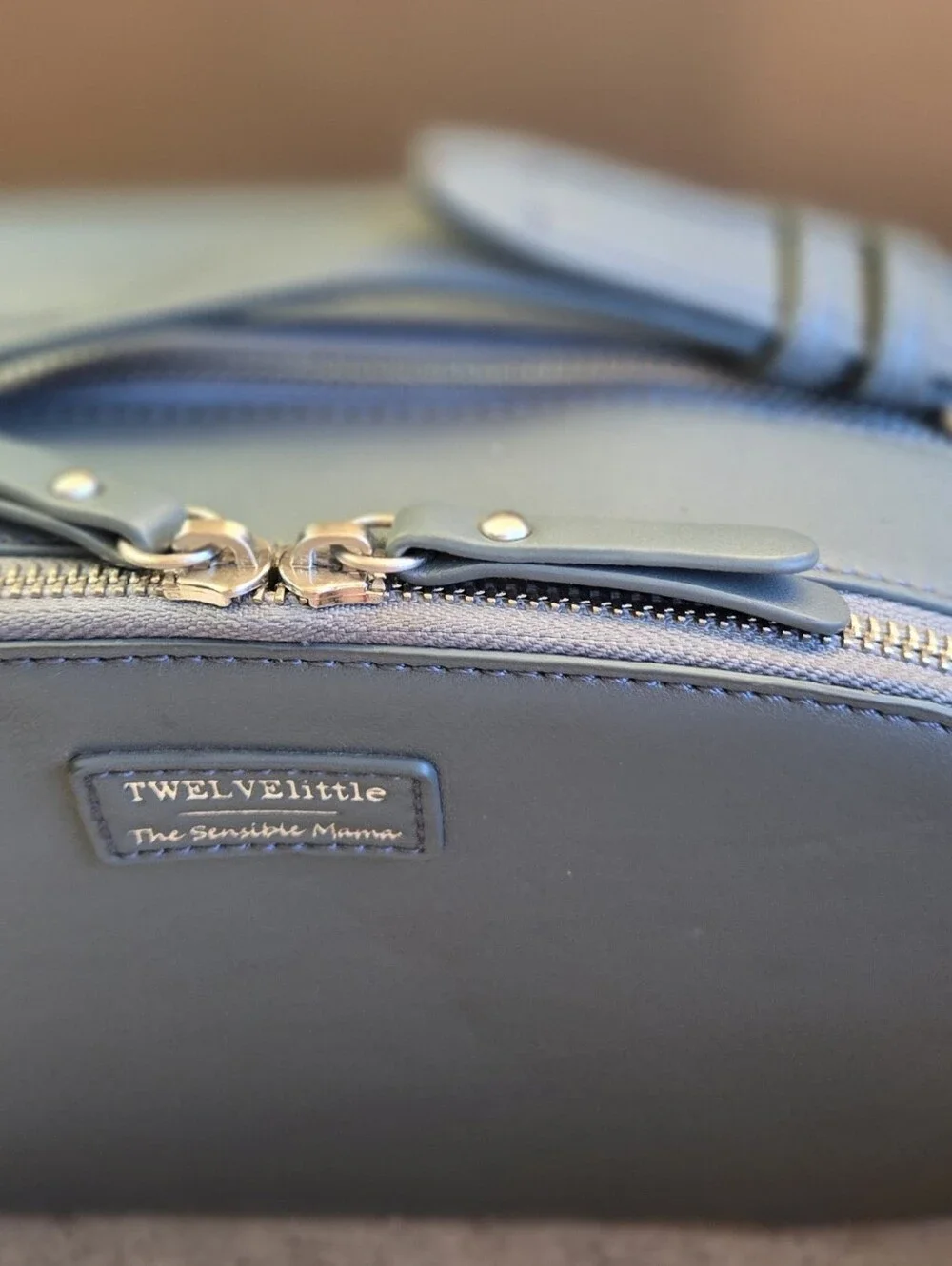 This is a TWELVElittle x The Sensible Mama Clutch in a muted blue vegan leather.